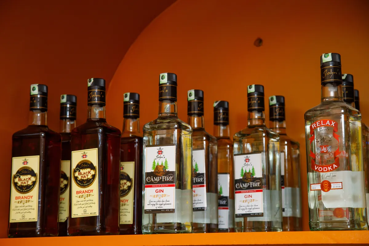 Camp Fire Gin, Relax Vodka, and Black Hat Brandy displayed on the branded shelf inside the JBL exhibition stand