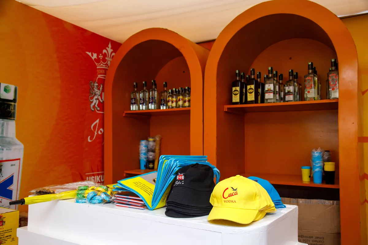 Branded caps and product bottles at the JBL merchandise counter, Nane Nane Grounds, Dodoma