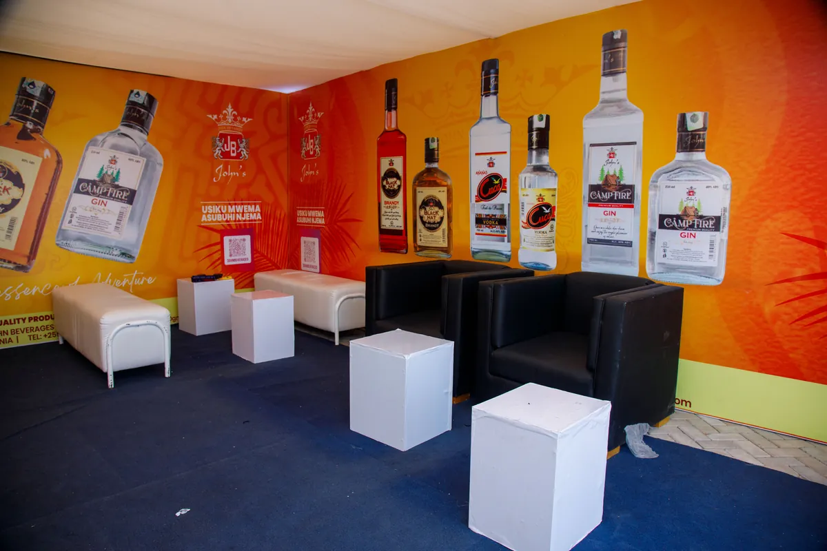 Branded lounge seating area inside the JBL stand featuring Camp Fire Gin and Black Hat Brandy wall displays